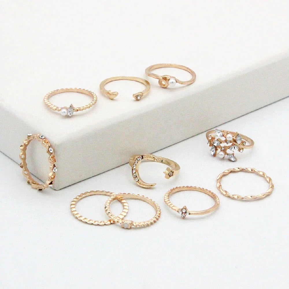 A set of 10 adjustable gold-plated rings with celestial-inspired designs including moons, stars, and pearls