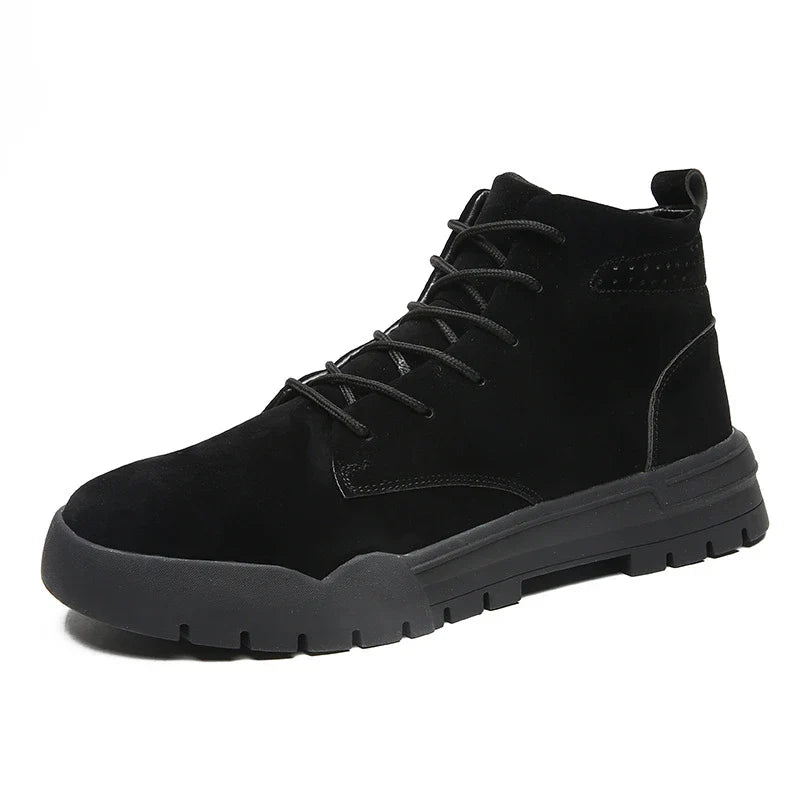 A pair of black, suede British-style Martin boots with a thick, rubber sole and round toe shape.