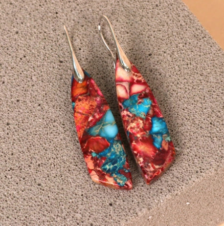 Geometric flower shape pendant earrings in copper with gold hooks, available in red, green, and blue.
