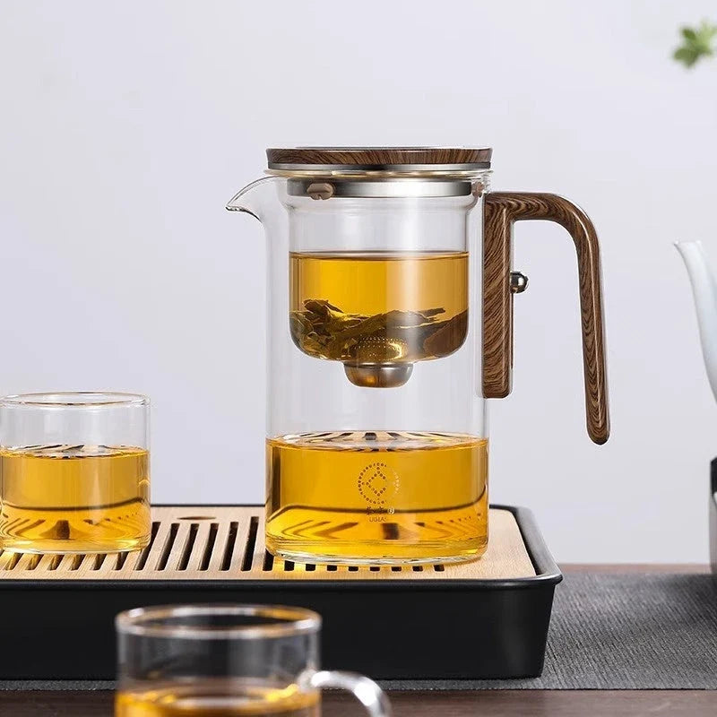 Smart one-button magnetic tea infuser pot with wooden handle, featuring heat-resistant borosilicate glass construction and seamless tea brewing experience.
