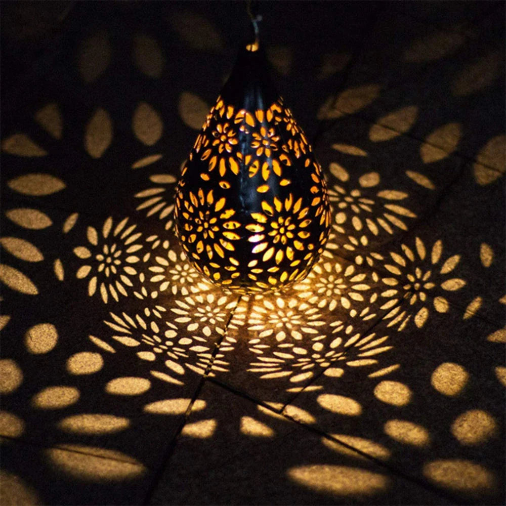 Solar-powered outdoor hanging lantern with flower-patterned shade, made of durable metal for long-lasting use in gardens, patios, and pathways.