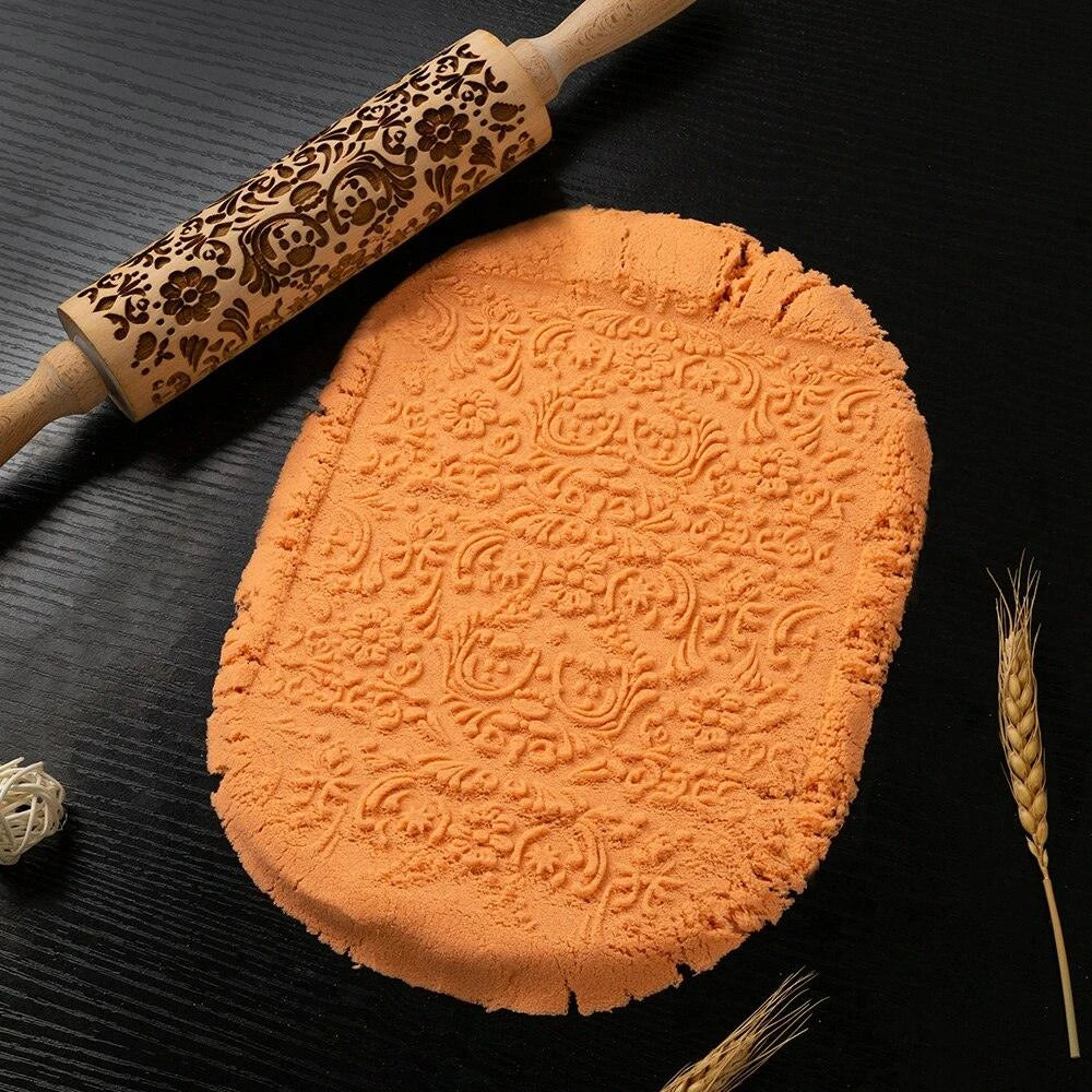 Embossed rolling pin made of natural wood with intricate designs for creating textured baked goods