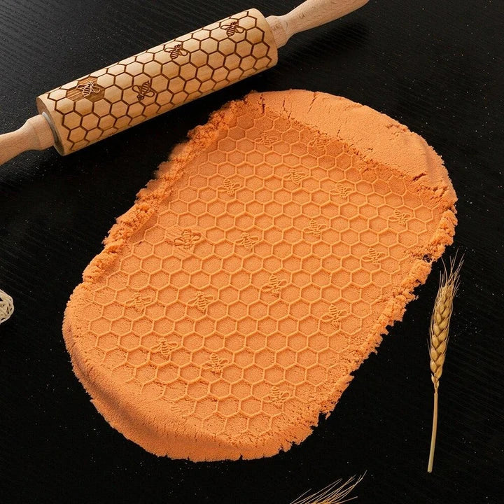 Embossed rolling pin made of natural wood with intricate designs for creating textured baked goods