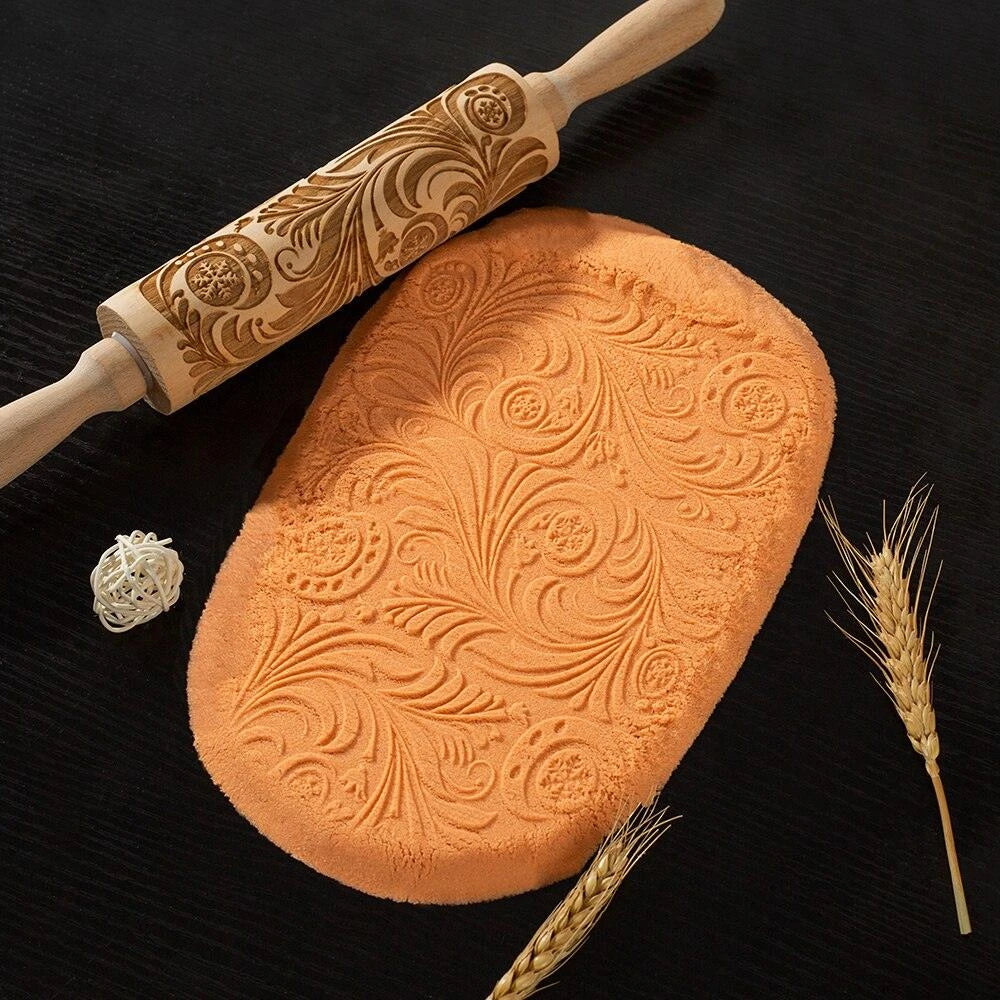 Embossed rolling pin made of natural wood with intricate designs for creating textured baked goods