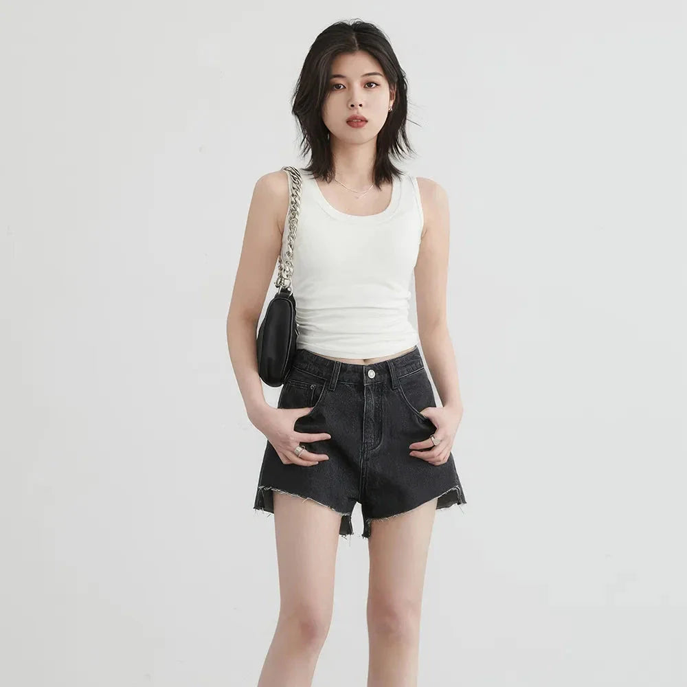 Women's high-waisted denim shorts with asymmetric hemline in black colour