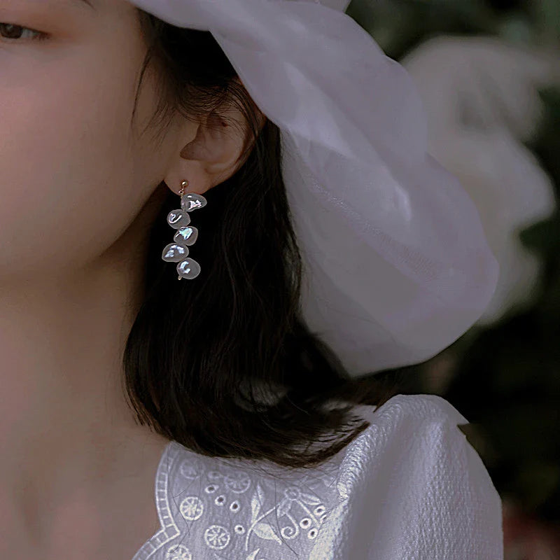 Pair of natural baroque pearl earrings with spiral clip design, featuring uniquely formed pearls in a shimmering display