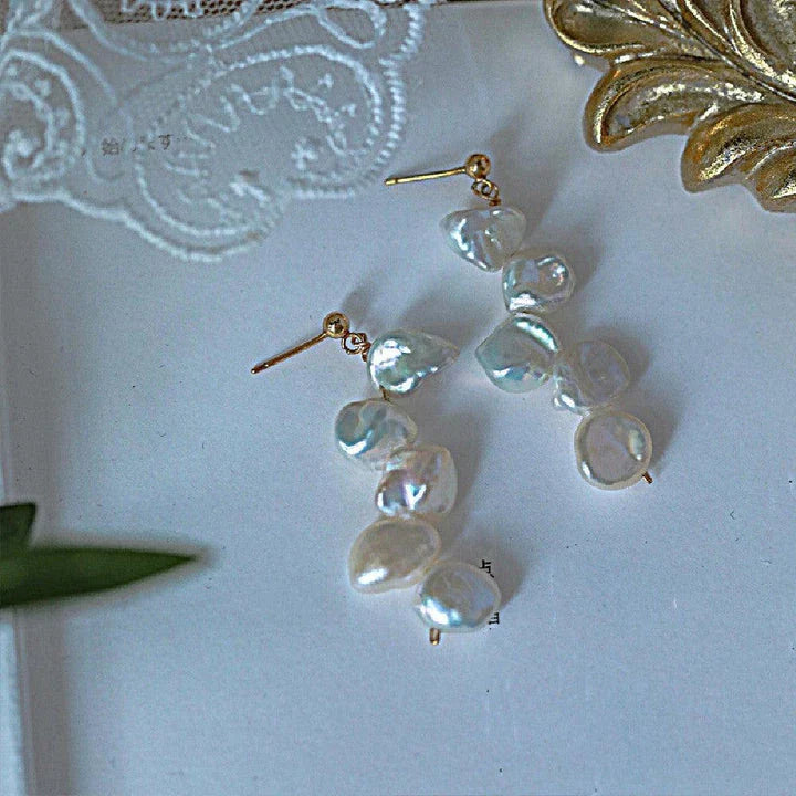 Pair of natural baroque pearl earrings with spiral clip design, featuring uniquely formed pearls in a shimmering display
