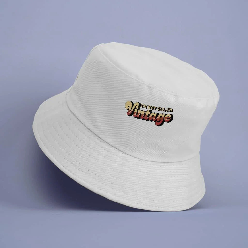 A vintage-inspired graphic bucket hat with a 'I'm Not Old I'm Vintage' design, made from high-quality materials for outdoor activities and casual wear.