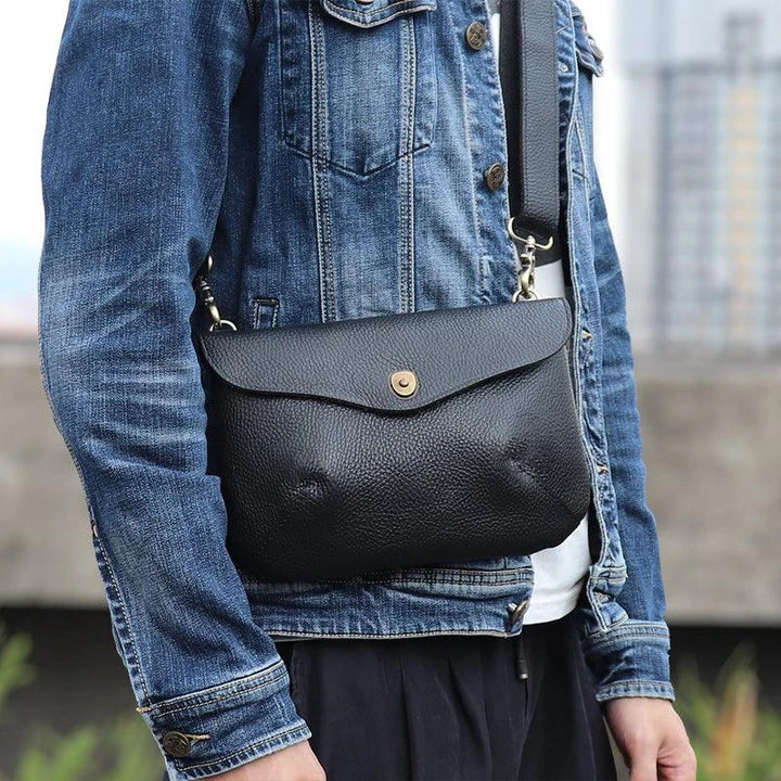 A vintage-inspired brown leather messenger bag with an adjustable strap and multiple interior compartments for organisation and storage.