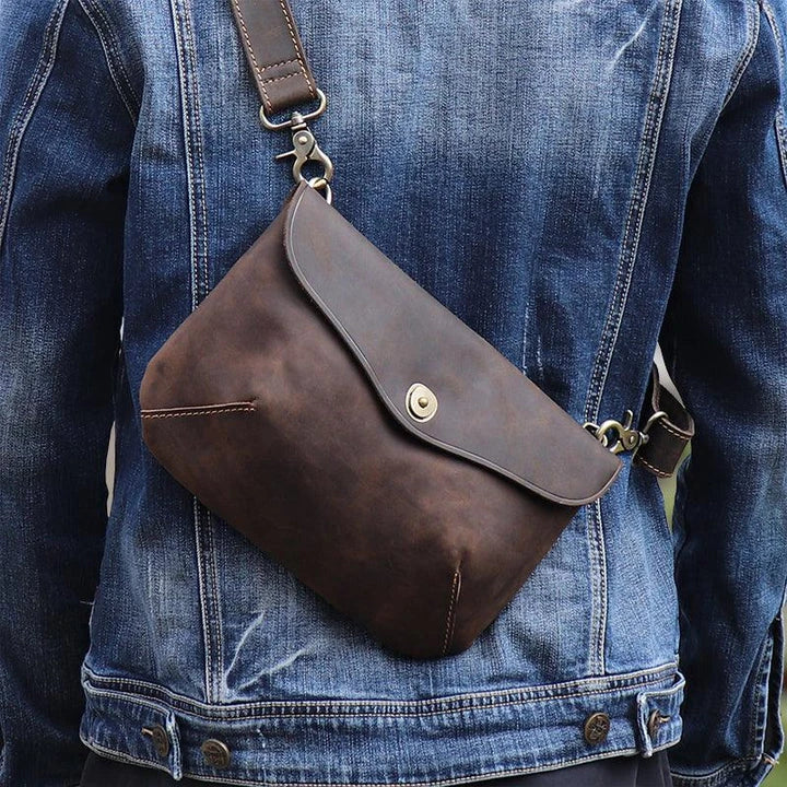 A vintage-inspired brown leather messenger bag with an adjustable strap and multiple interior compartments for organisation and storage.