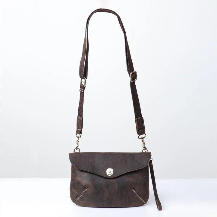 A vintage-inspired brown leather messenger bag with an adjustable strap and multiple interior compartments for organisation and storage.