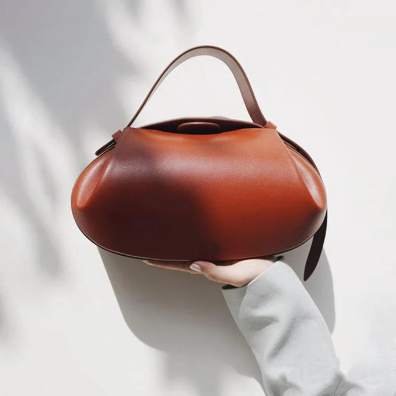 Elegant round vegan leather handbag with a distinctive circular shape, durable construction, and spacious interior organisation
