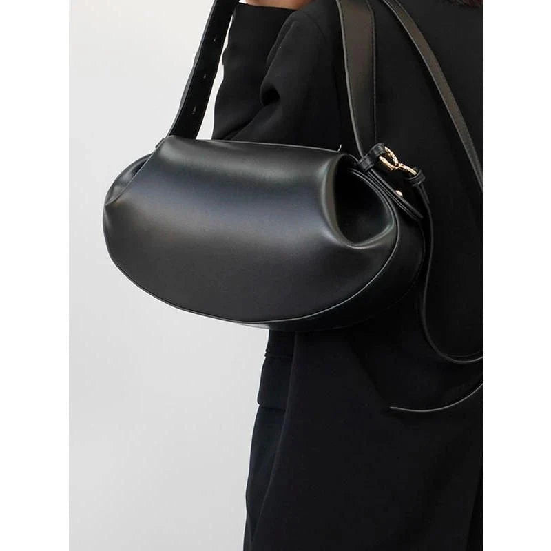 Elegant round vegan leather handbag with a distinctive circular shape, durable construction, and spacious interior organisation