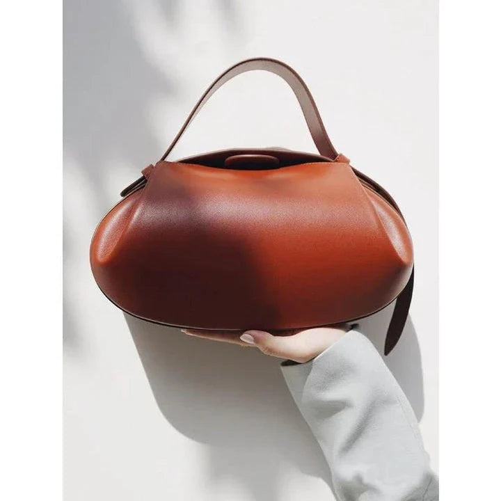 Elegant round vegan leather handbag with a distinctive circular shape, durable construction, and spacious interior organisation