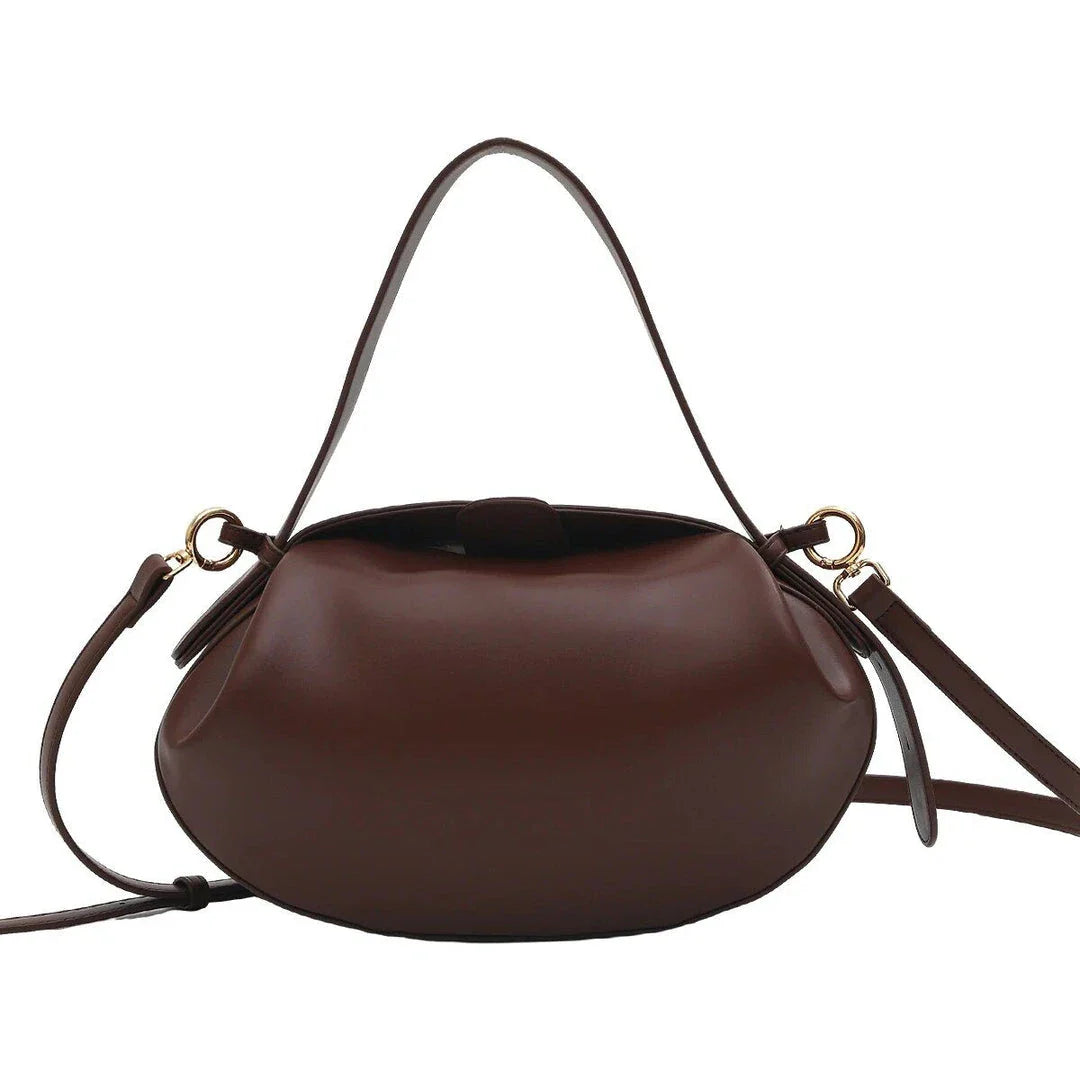 Elegant round vegan leather handbag with a distinctive circular shape, durable construction, and spacious interior organisation