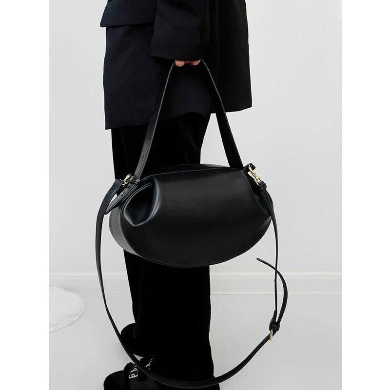 Elegant round vegan leather handbag with a distinctive circular shape, durable construction, and spacious interior organisation