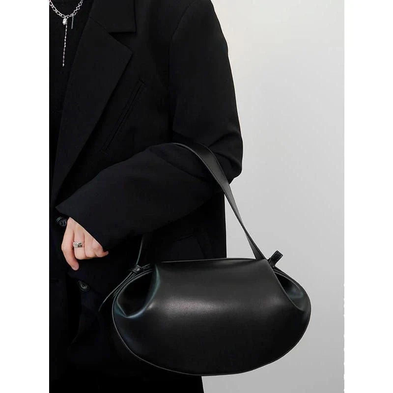 Elegant round vegan leather handbag with a distinctive circular shape, durable construction, and spacious interior organisation