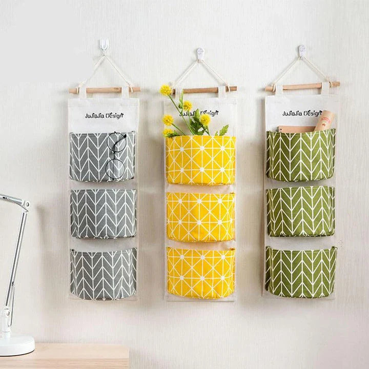 A green hanging storage bag with three compartments, designed to neatly organise everyday items in the home.