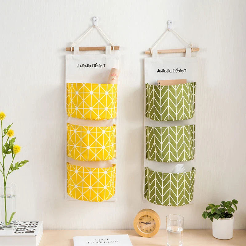 A green hanging storage bag with three compartments, designed to neatly organise everyday items in the home.