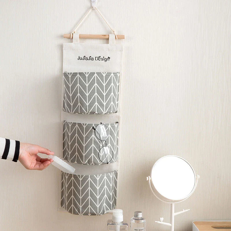 A green hanging storage bag with three compartments, designed to neatly organise everyday items in the home.