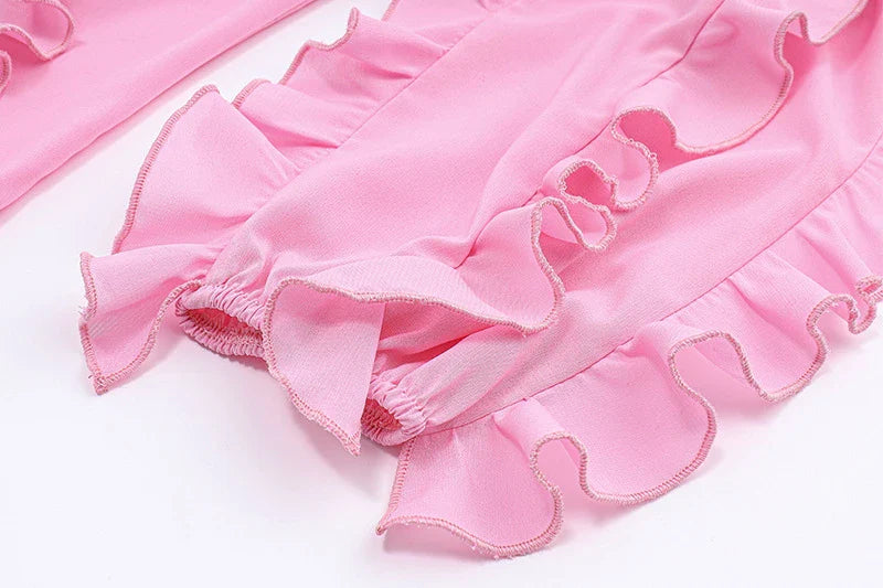 A girls' short top with a v-neck, ruffled trim, and a heart-shaped bow tie, made from stretchy chiffon fabric