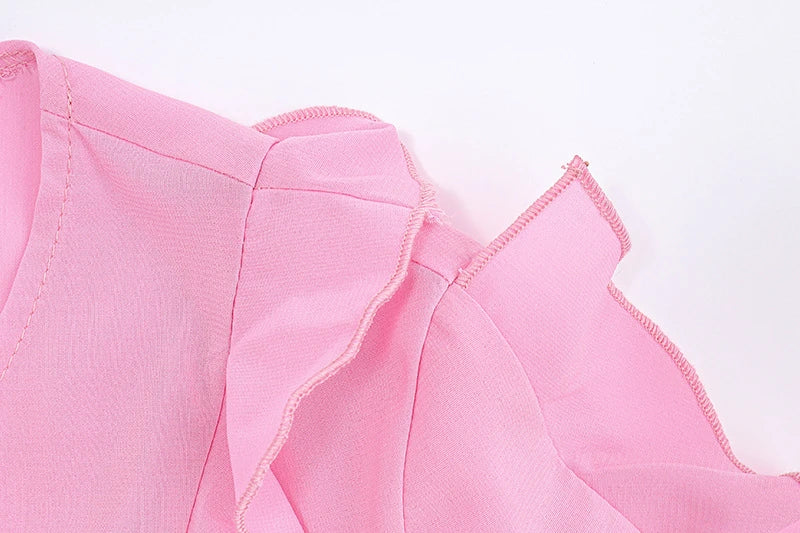 A girls' short top with a v-neck, ruffled trim, and a heart-shaped bow tie, made from stretchy chiffon fabric