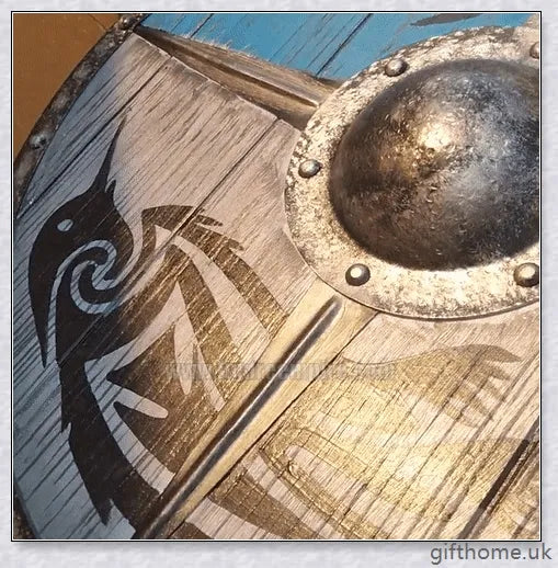 Authentic battle-worn Viking shield with two ravens design and iron spikes, adorned with Celtic buckle and rune characters