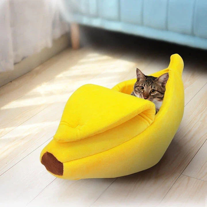 Cosy banana-shaped bed for cats in bright yellow colour, providing a comfortable and stylish resting spot for felines.