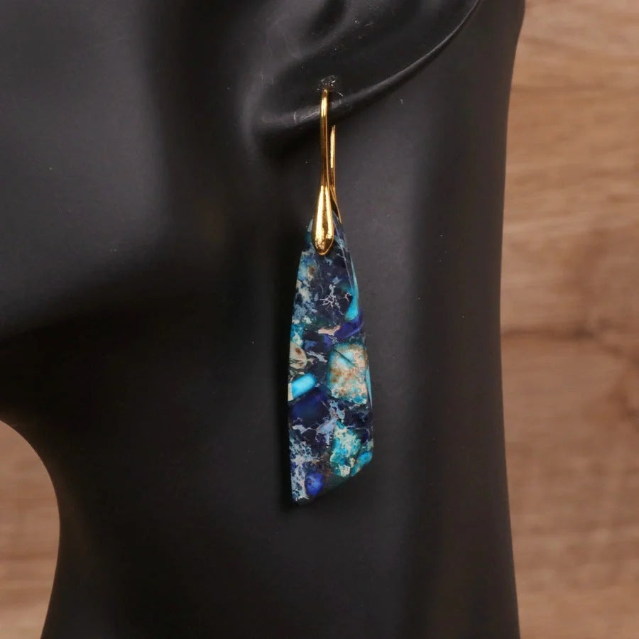 Geometric flower shape pendant earrings in copper with gold hooks, available in red, green, and blue.