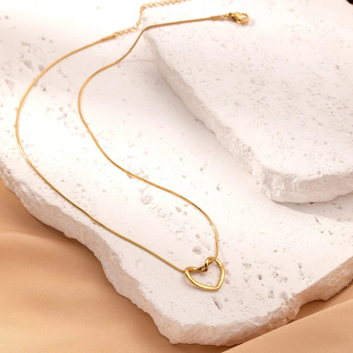 Titanium steel heart pendant necklace in gold and silver finishes, featuring an elegant and adjustable design for a customized fit