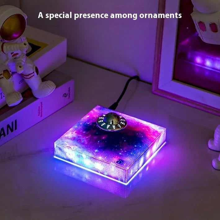 Futuristic levitating UFO lamp with color-changing lights and Milky Way galaxy base