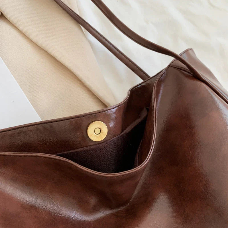Premium faux leather shoulder bag in various colors, featuring a classic silhouette and roomy interior for everyday convenience.