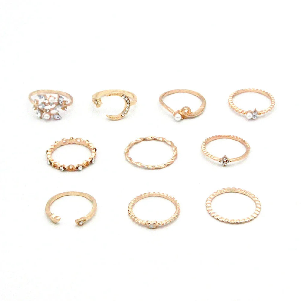 A set of 10 adjustable gold-plated rings with celestial-inspired designs including moons, stars, and pearls
