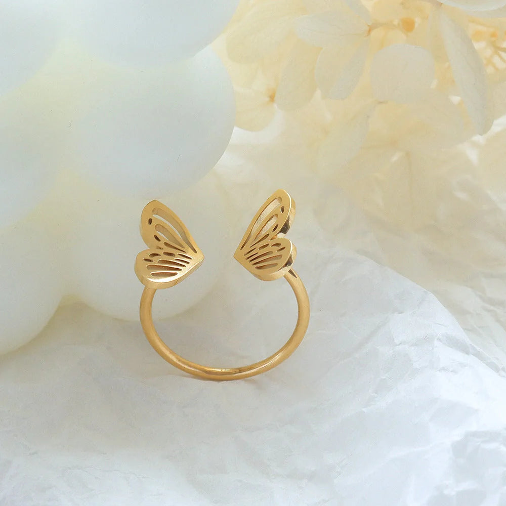 Adjustable hollow butterfly ring in titanium steel, available in golden and steel colours.