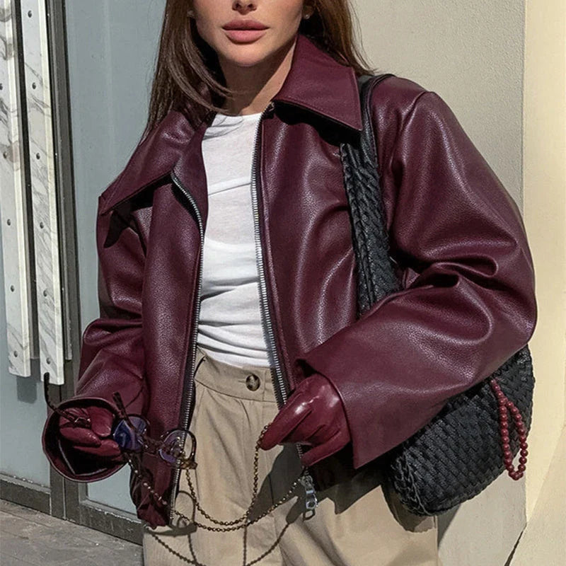 Fashionable faux leather jacket in burgundy and black colors, featuring a zipper closure and long sleeves for casual, versatile wear