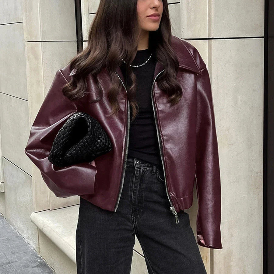 Fashionable faux leather jacket in burgundy and black colors, featuring a zipper closure and long sleeves for casual, versatile wear