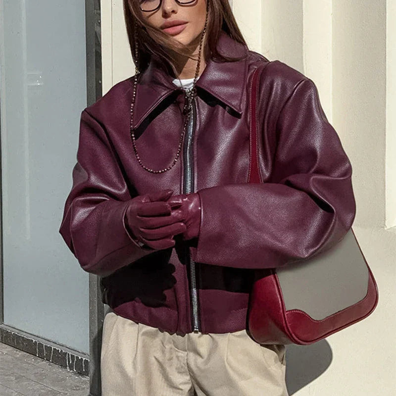 Fashionable faux leather jacket in burgundy and black colors, featuring a zipper closure and long sleeves for casual, versatile wear