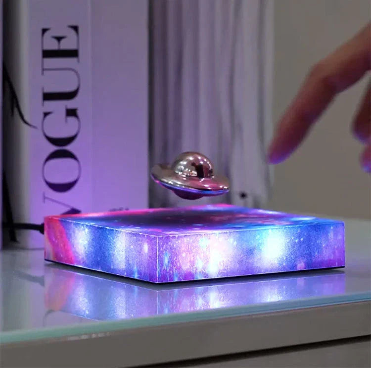 Futuristic levitating UFO lamp with color-changing lights and Milky Way galaxy base