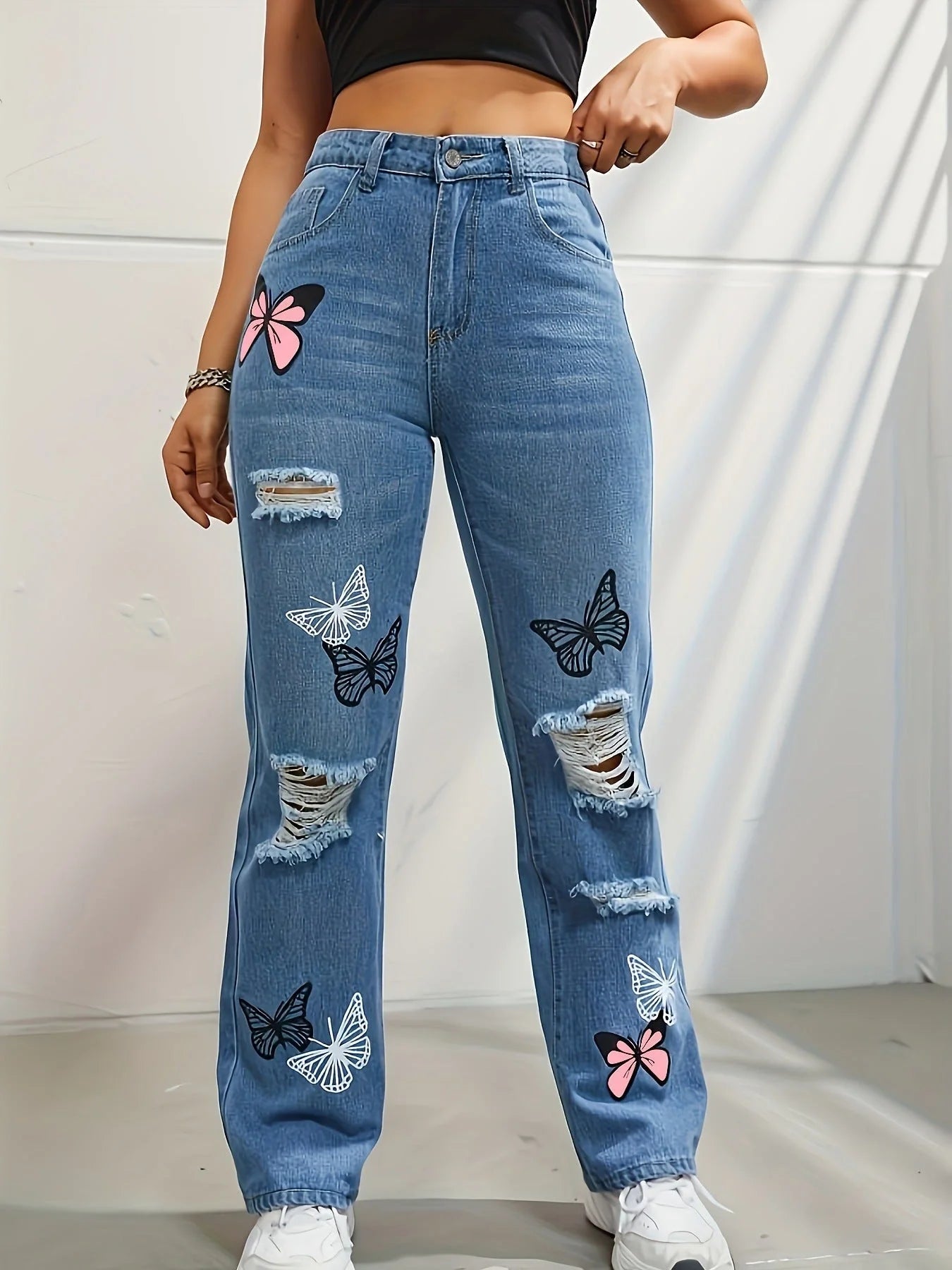 High-waisted straight leg jeans with trendy butterfly print, distressed detailing, and button closure for a stylish, flattering look.