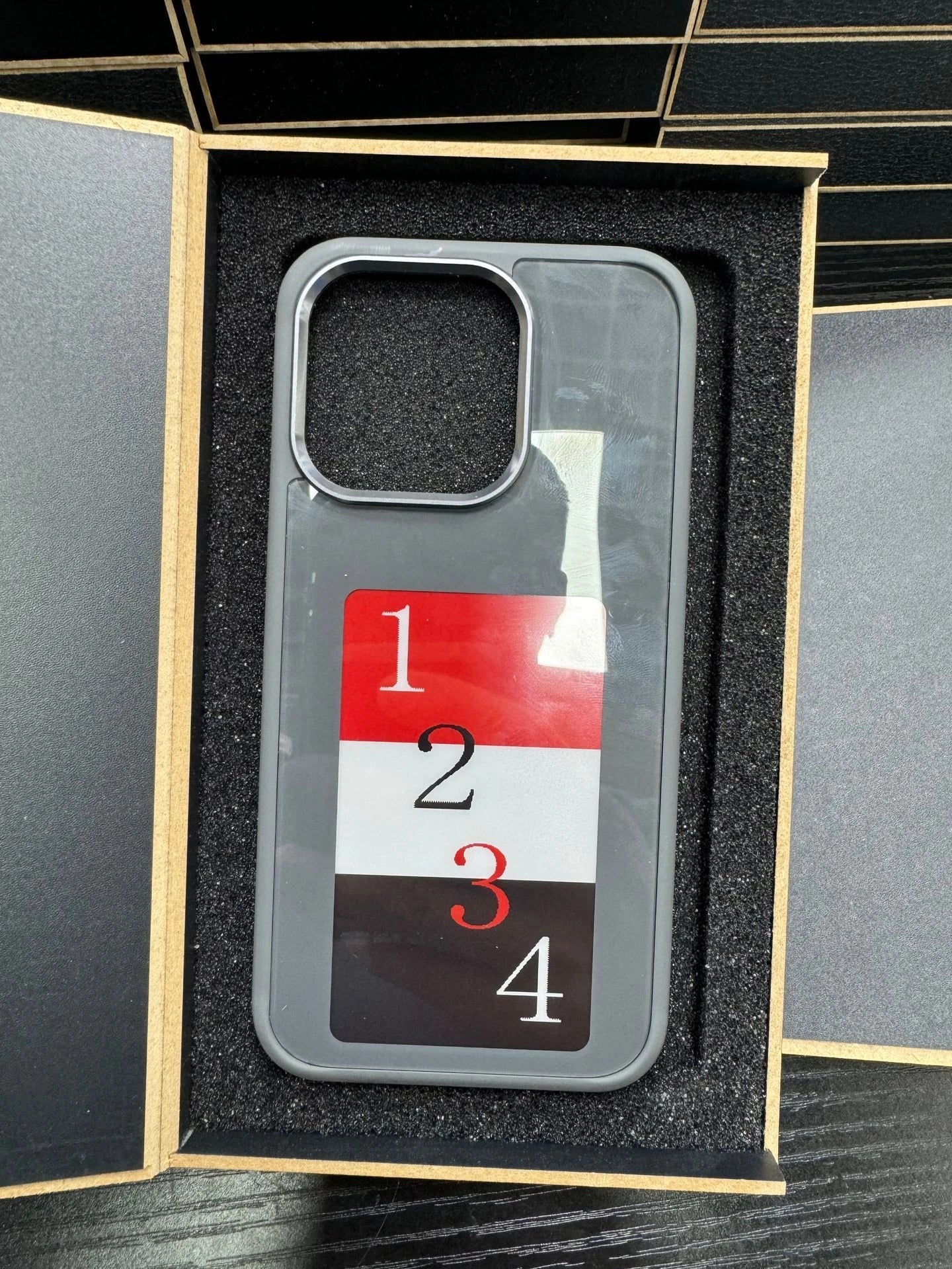 A customizable phone case with an e-ink display that allows users to wirelessly project their preferred images.