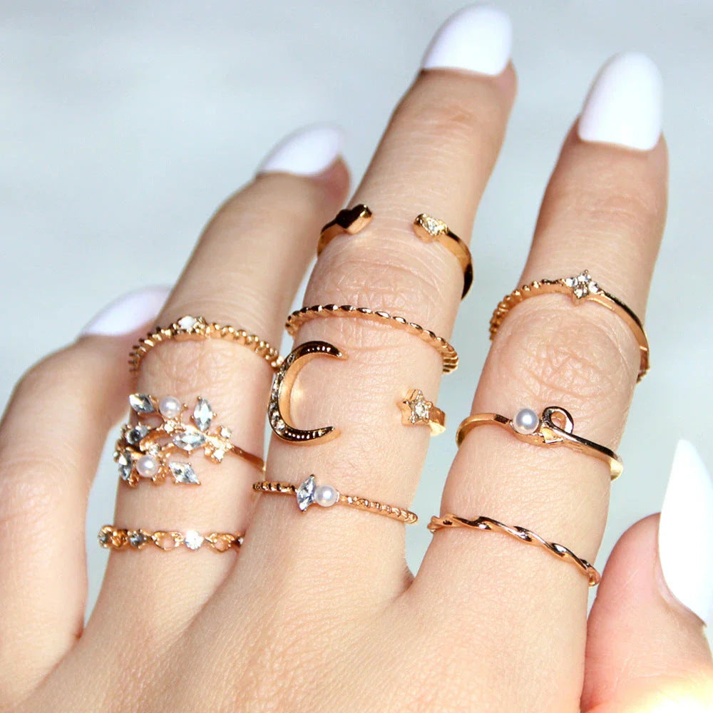 A set of 10 adjustable gold-plated rings with celestial-inspired designs including moons, stars, and pearls