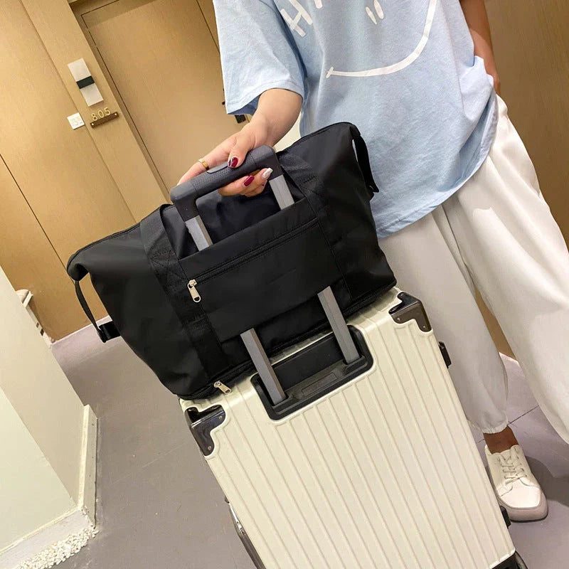 Expandable travel duffel bag with adjustable shoulder strap, multiple interior pockets, and water-resistant Oxford cloth material