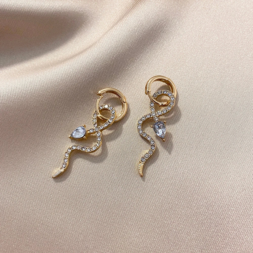 Elegant gold-toned snake charm earrings with a dangle design, perfect for adding a touch of sophistication to any outfit.