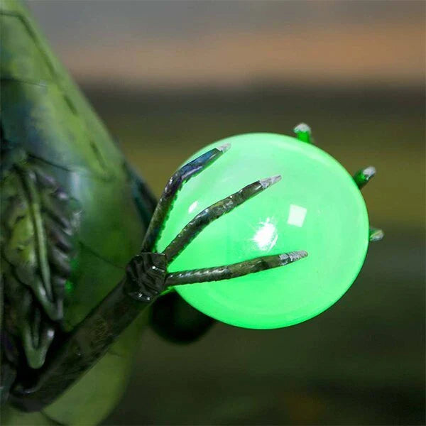 Enchanting green dragon garden statue with serene expression and solar-powered illuminating orb