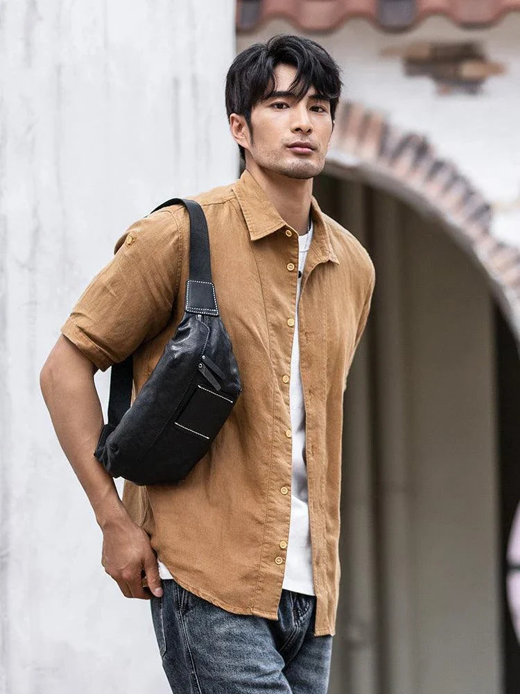 Premium cowhide messenger bag in black, featuring a spacious interior, adjustable shoulder strap, and sleek, minimalist design
