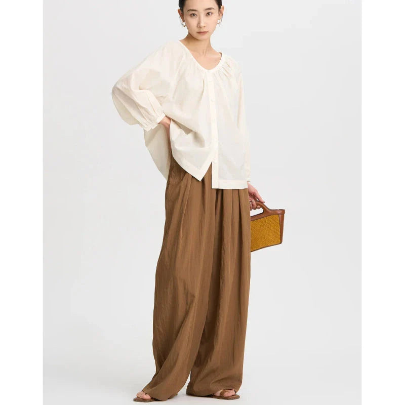 Pleated wide-leg high-waisted trousers in a herringbone plaid pattern, featuring a flattering silhouette and comfortable cotton-linen blend