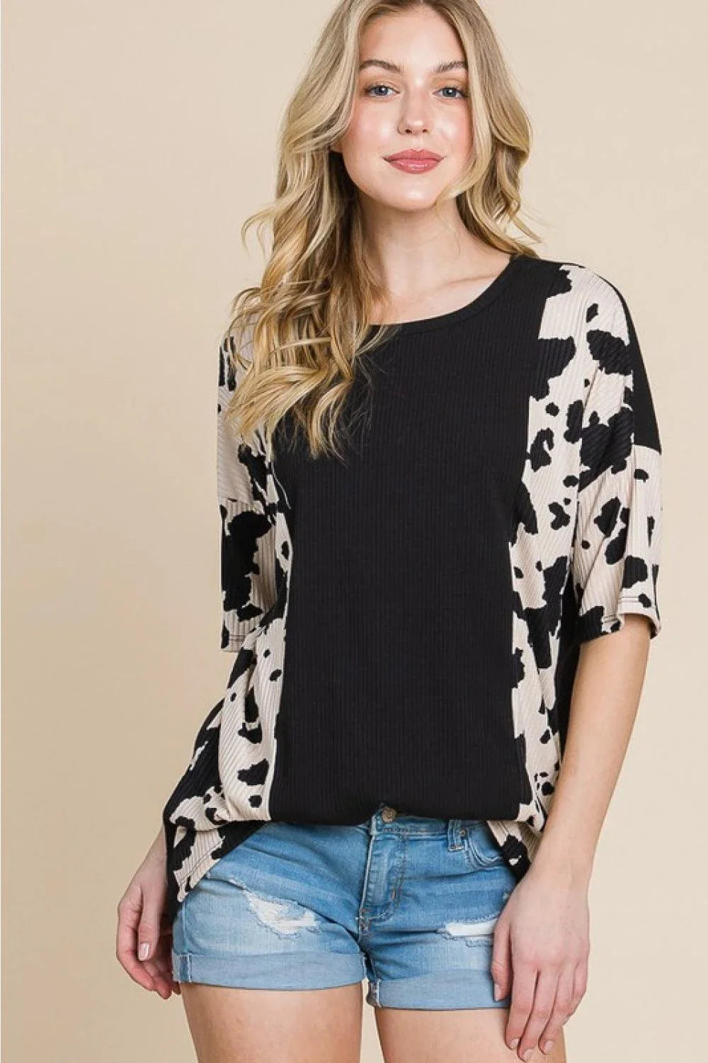 Stylish ribbed tee with playful cow print design, perfect for casual and smart-casual occasions.