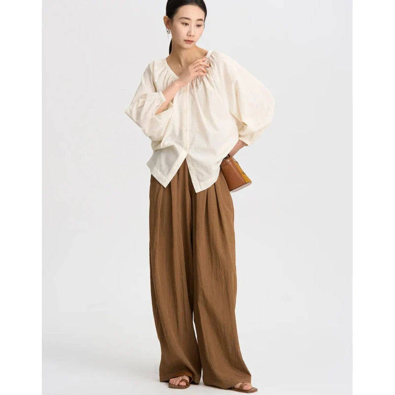 Pleated wide-leg high-waisted trousers in a herringbone plaid pattern, featuring a flattering silhouette and comfortable cotton-linen blend