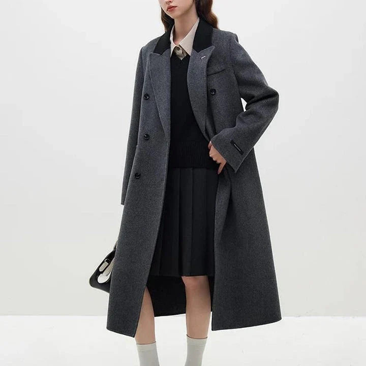 A sophisticated and stylish dark grey woollen coat for women, designed with a timeless double-breasted closure and notched collar.