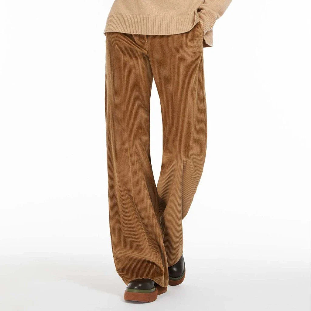 A pair of high-waist, wide-leg corduroy trousers in a classic red colour, designed for the modern British woman's wardrobe.